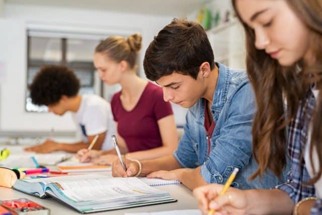 A decorative stock image shows a group of students studying.