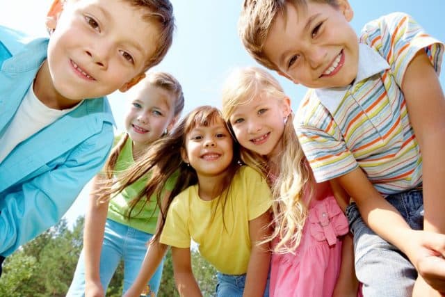 Decorative stock image shows a group of children smiling at the camera.