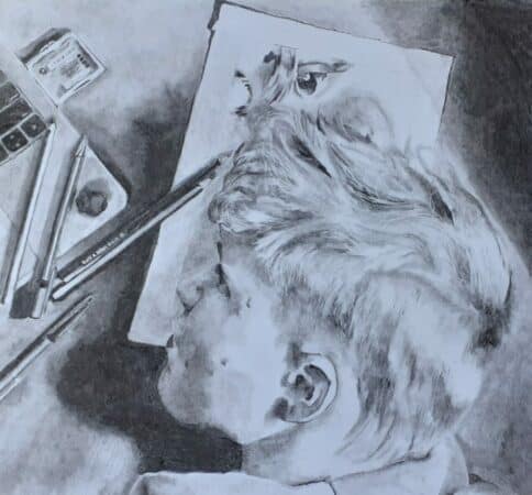 A charcoal drawing of a young man with his head on his desk, staring at his drawing tools.  Above him is an unfinished drawing. This drawing is titled Perfectionism by Toby Maclean. 